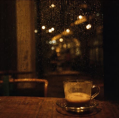 Coffee beside a rain-streaked café window